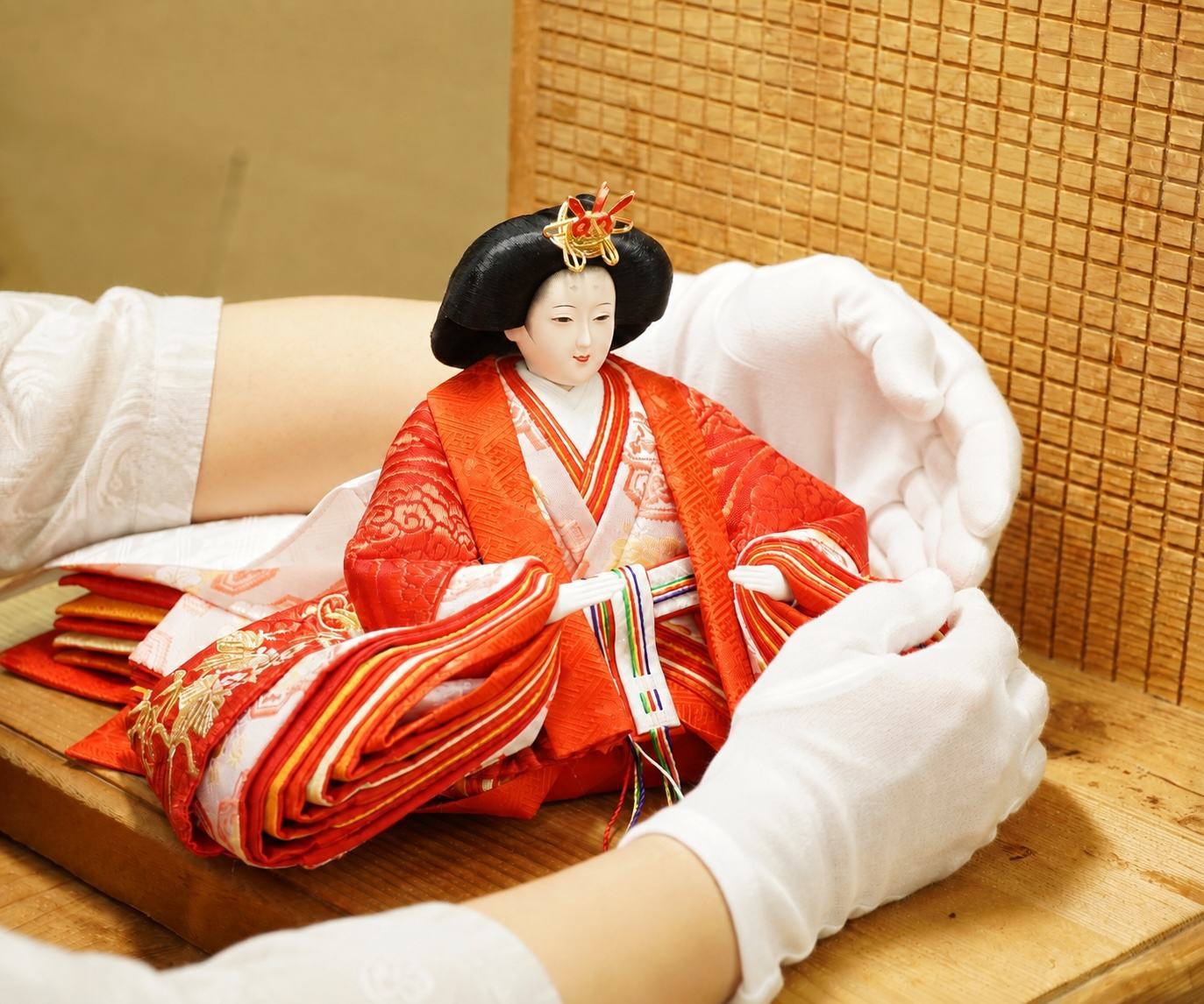 白手袋の伝統工芸士が雛人形を丁寧に扱う様子（人形供養のお預かり）